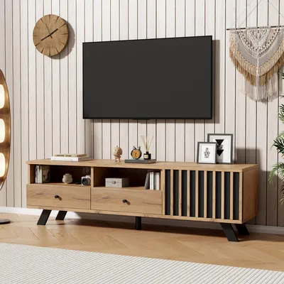 A TV stand with a television mounted above it, in a room with wood-paneled walls.