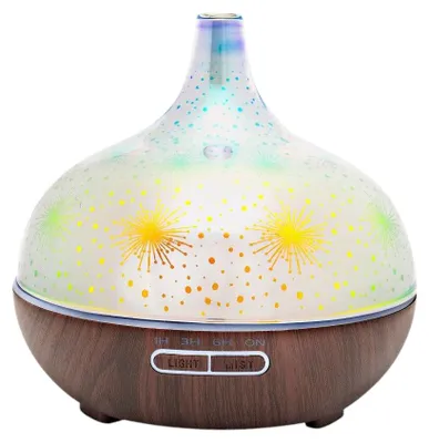 A close-up studio shot of an aroma diffuser with a wood-look base and a patterned glass dome.