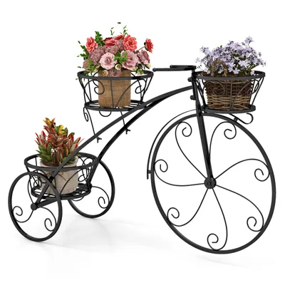 A black metal bicycle-shaped plant stand with three baskets holding potted plants.