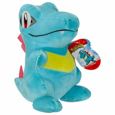 A blue plush toy of a Pokemon character, likely Totodile, with a tag attached.