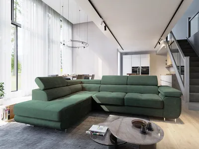 A modern living room with a large green sectional sofa, a coffee table, and a staircase in the background.