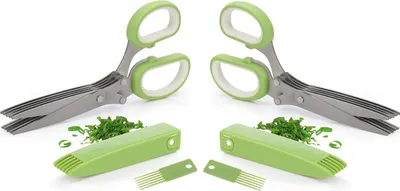 Two herb scissors with green handles and white accents are shown, along with their protective covers and some chopped herbs.