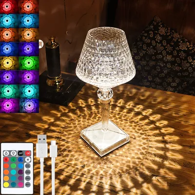 A crystal table lamp is shown on a wooden surface, casting intricate light patterns. A remote control and USB cables are also visible.