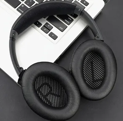 A pair of black over-ear headphones rests on a laptop keyboard.