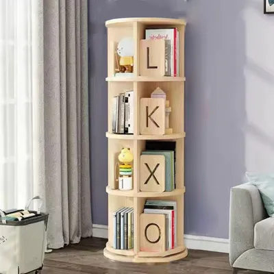 A wooden rotating bookshelf with books and decorative items on it, placed next to a curtain and a sofa.