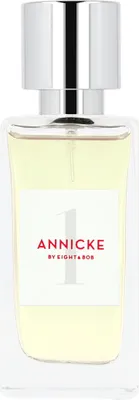 A perfume bottle with a silver cap and a white label.