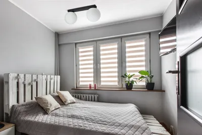 A bedroom with a bed, window, and ceiling light.