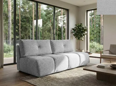 A modern living room with a large sofa and a view of a forest through floor-to-ceiling windows.