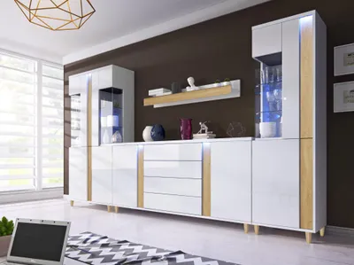 A modern living room with a large white and wood cabinet set.