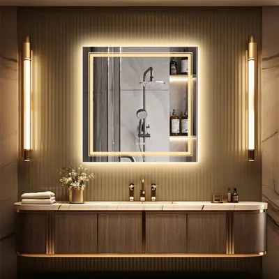 A modern bathroom vanity with a large illuminated mirror, two wall sconces, and a sink.
