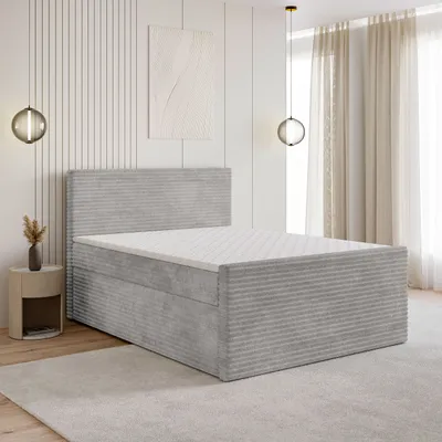 A bedroom scene with a bed, nightstand, and wall decor.