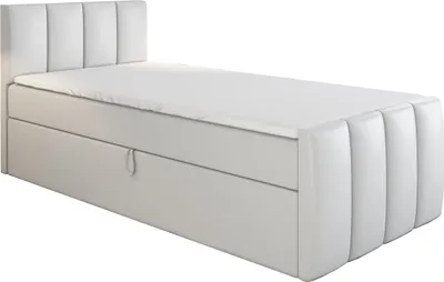A white boxspring bed with a mattress and topper, shown from a side angle.