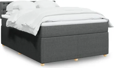 A bed with white bedding and a gray upholstered base and headboard, presented on a white background.