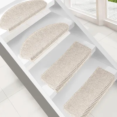 Several cream-colored stair mats are placed on white stairs.