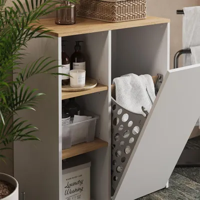 A close-up view of a bathroom cabinet with open shelves and a laundry basket, showcasing storage solutions.