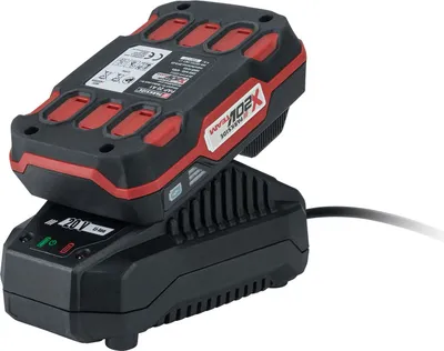 A black and red battery charger with a battery pack on top, against a white background.