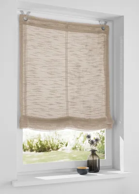 A Roman blind is installed on a window, with a view of greenery outside. A small vase with dried flowers and a bowl are on the windowsill.
