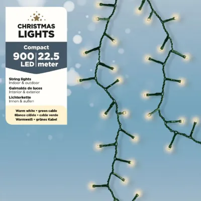 A string of Christmas lights with warm white LEDs and a green cable against a light blue background with bokeh effects.