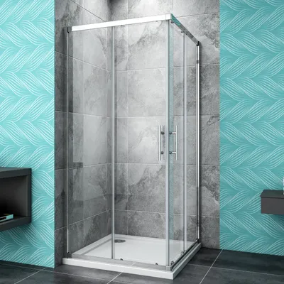 A modern shower enclosure in a bathroom setting with tiled walls and a patterned wallpaper.