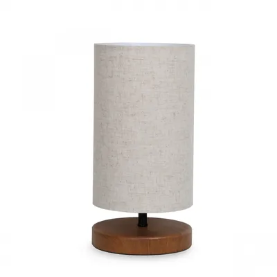 A table lamp with a cylindrical fabric shade and a wooden base, presented on a white background.