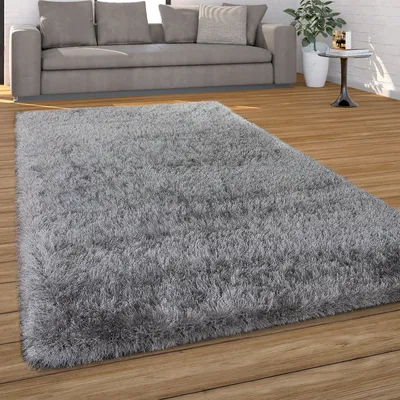 A shaggy rug in a living room setting with a sofa and side table.