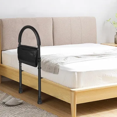 A bedside safety rail attached to a wooden bed frame.