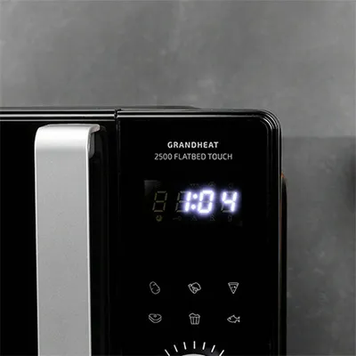 A close-up view of the digital display and control panel of a black microwave oven.