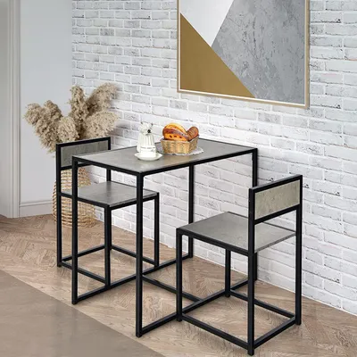 A three-piece bar set with a table and two stools against a white brick wall.