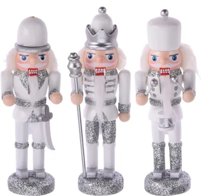 Three white nutcracker figures with silver accents and red bows, standing on a white background.