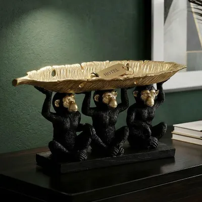 Immagine prodotto di Mauro Ferretti, statuina decorativa raffigurante un trio di scimmie con una ciotola a forma di foglia, dimensioni 43x15,7x20 cm, colore nero e oro