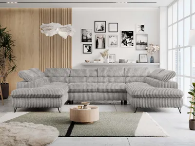 A modern living room with a large U-shaped sectional sofa, a coffee table, and decorative items on the wall.
