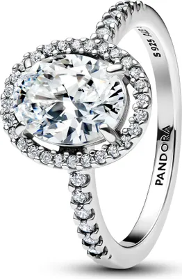 A close-up studio shot of a Pandora ring with a large oval-cut clear stone surrounded by smaller clear stones, set on a silver band.
