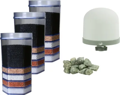 A collection of water filter components, including three filter cartridges, a filter dome, and a pile of mineral stones, arranged on a white background.