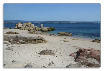 Produktbild von Wallario Frühstücksbrettchen aus Glas 20 x 30 cm mit rutschfesten Füßen, Motiv Felsen auf einem Sandstrand