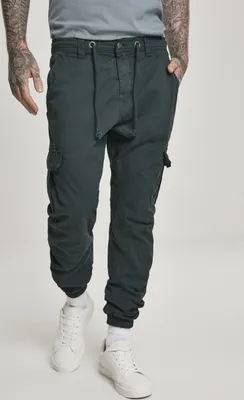 A person wearing black cargo jogging pants and white sneakers, standing against a white background.