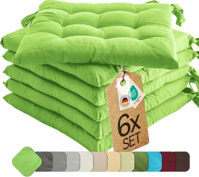 A stack of six green seat cushions with a tag attached.
