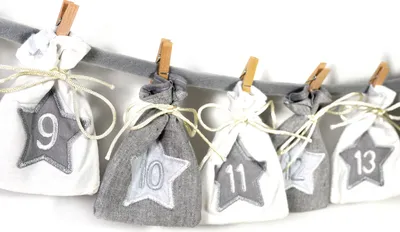 A row of small fabric bags, each with a star applique and a number, hanging on a string.