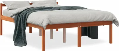 A wooden bed frame with bedding and a blanket.