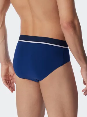 Productafbeelding van Schiesser 3-pack Rio slips/onderbroeken, gemaakt van 95% biologisch katoen en 5% elastaan. Sportieve elastische band met opvallend logo, comfortabele zijsplitjes, en gemaakt van een perfect zittende, elastische single-jersey kwaliteit