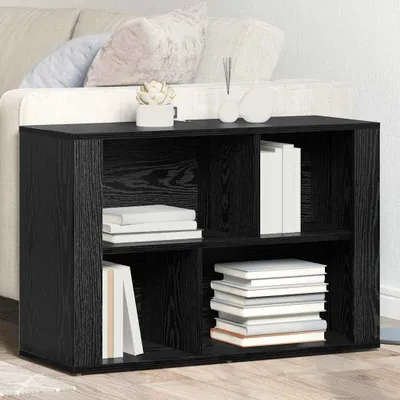 A black wooden sideboard with shelves, filled with books, placed in front of a sofa.