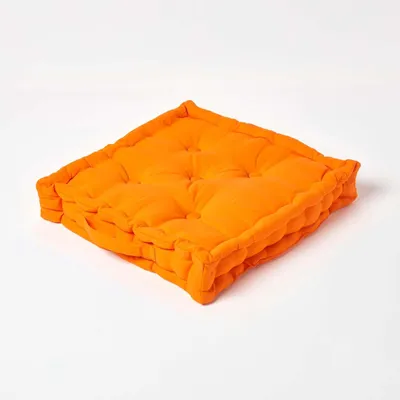 A single orange floor cushion on a white background.