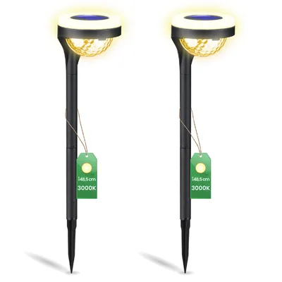 Two black solar garden lights with yellow light and green tags.