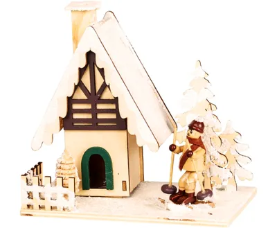 Ein Räucherhaus als winterliche Holzhütte, die mit Schnee bedeckt ist. Vorgarten mit Skifahrer..