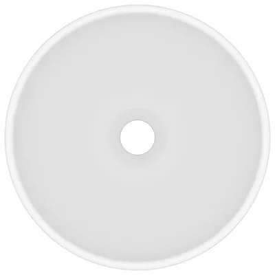 A top-down view of a white ceramic sink with a drain hole in the center.