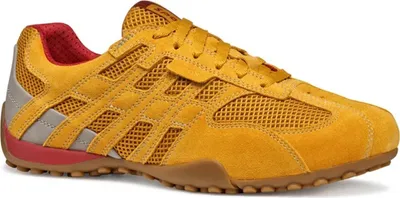 A side view of a yellow athletic shoe against a white background.