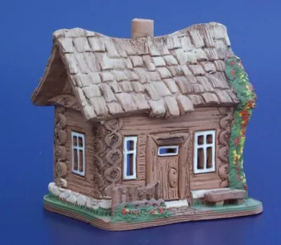 Ein handgefertigtes Keramikmodell eines kleinen Schneiderhauses. Die Farbpalette ist erdig.