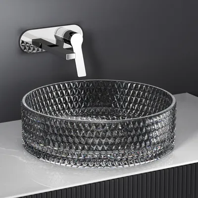A modern bathroom sink setup with a glass basin and a wall-mounted faucet.