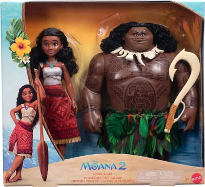 A blister pack containing two Moana 2 dolls, Maui and Moana, with a paddle and a hook accessory. The packaging features a beach scene and the Moana 2 logo.