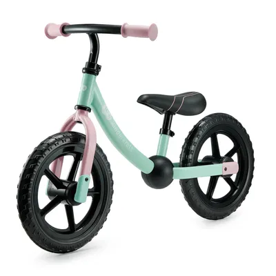 A mint green and pink balance bike with black wheels, shown from a three-quarter front angle against a white background.