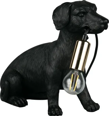 A black dog figurine holding a light bulb in its mouth, on a white background.